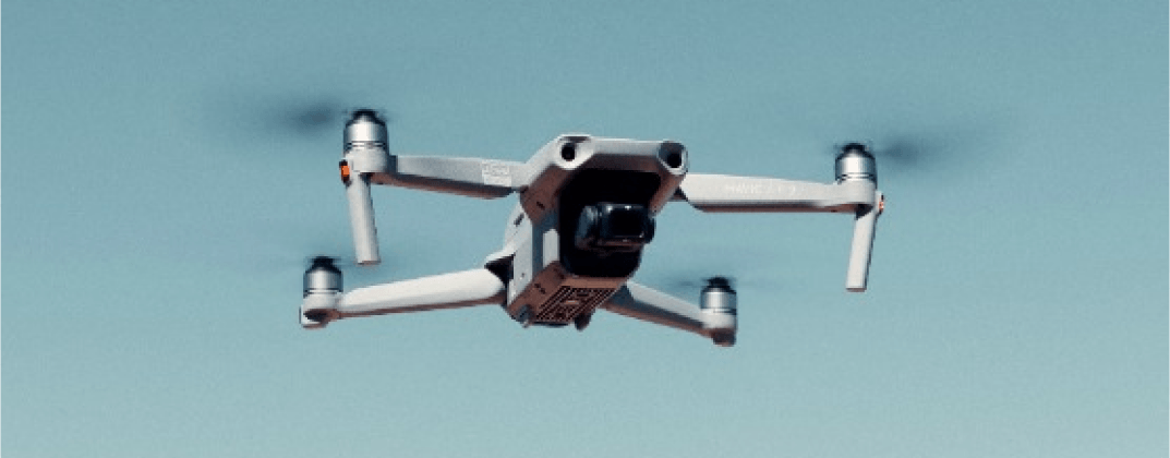 White drone flying in the blue sky