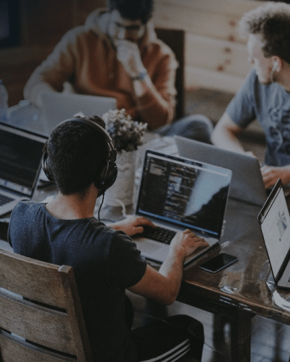 A group of men sitting with laptops