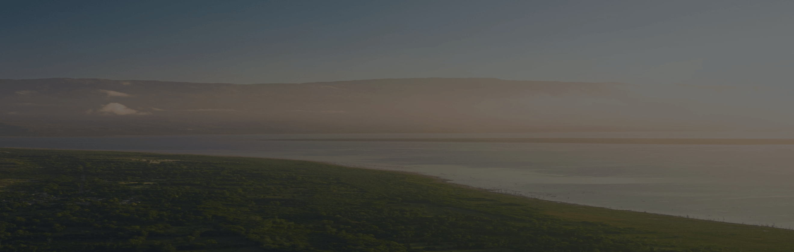 A view of the green landscape with a sea on the horizon